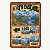 North Cascades National Park facts aluminum sign featuring glacier-covered peaks, alpine lake, Washington map, mountain goat, and park facts